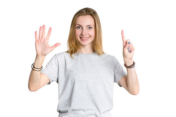 Wall Mural - Portrait of a young woman who shows fingers the number six on a white background. Pointing hand the number 6.