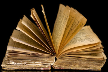 Open  old holy  book . On black background. Symbols of Christianity . Close-up . Religion concept.