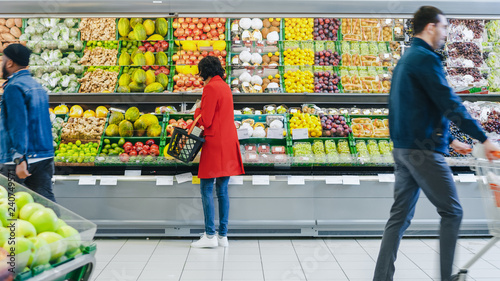 Cuadros en Lienzo At the Supermarket: Woman Chooses Organic Fruits in the Fresh Produce Section of the Store