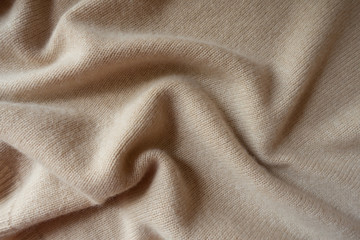 Pale beige knitted fabric in soft folds