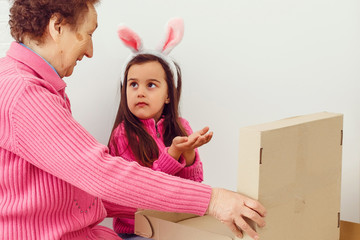 Wall Mural - Mom grandmother and little girl open gift boxes repair apartment