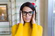 © nenetus - Beautiful young woman showing her new eyeglasses while looking at camera in optic shop.