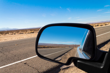 Wall Mural - Looking through a rear view mirror  on a pickup truck in the Mojave Desert in California