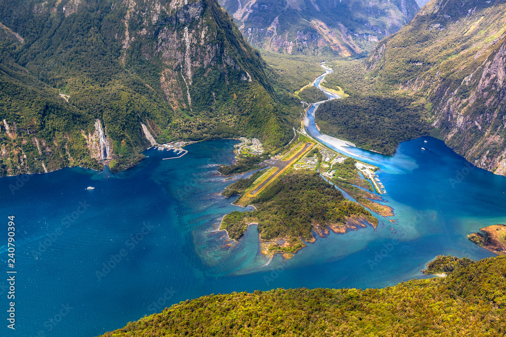 Obraz na płótnie New Zealand. Milford Sound (Piopiotahi) from above - the head of the fiord with wharf and Milford Sound Airport. There is Cleddau River in the background w salonie