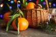 Composition with ripe tangerines and blurred Christmas lights on background