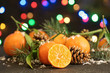 Ripe tangerines, artificial snow and blurred Christmas lights on background