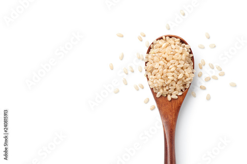 Fotografía Brown rice in a wooden spoon isolated on white background