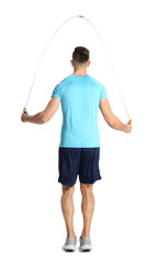 Wall Mural - Sportive man training with jump rope on white background