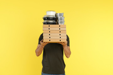 Poster - Young courier with different orders on color background. Food delivery service