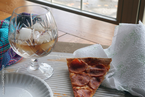 Fotografie, Obraz Leftover slice of pepperoni pizza with cola soft drink on ice in a glass