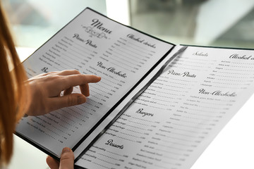 woman reading menu in cafe, closeup