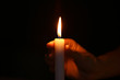 © Pixel-Shot - Female hand with burning candle in darkness