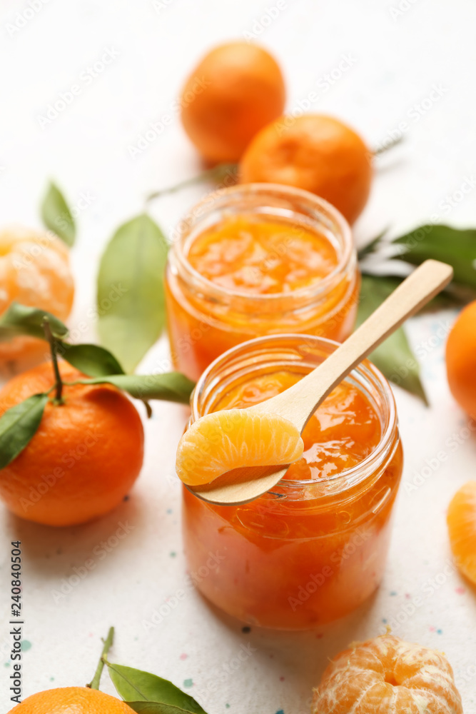 Jars of tasty tangerine jam on light table