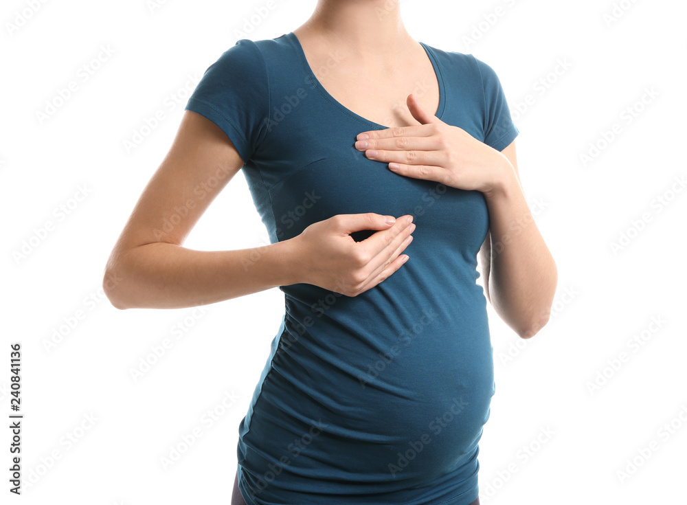 Pregnant woman touching her breast on white background