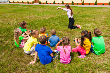 Canvas Print - Back view of children spending time outside and playing charades