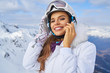 © ZoomTeam - Attractive young woman at a mountain ski resort. Standing on a snow chatting on her mobile phone and laughing