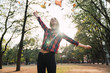 © Westend61 - Happy young woman throwing autumn leaves in the air