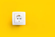 white electrical outlet on isolated yellow background