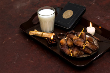 plate dates, rosary muslim, holy book quran, candle and milk cup on tray 