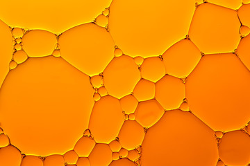 Abstract background of orange oil drops on water
