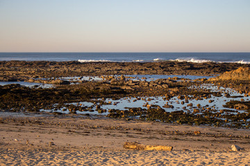 Atlantic Ocean coast in Portugal, Europe. Morning beach with rocks. Beach at sunset. Seascape at dawn. Summer evening coastline. Scenic panorama seashore.