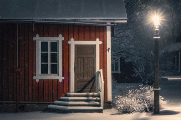 Public cozy old cafe place with snow mood at winter evening in Finland. Light snowflakes. This place is open only in summer time.