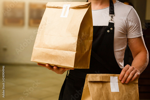 Fotomural Two boxes with fast food being carried by delivery man in uniform for one of cli