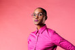 © Carlos David - Portrait of a young woman with glasses and pink shirt, isolated on pink studio background