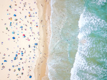 An Aerial View Of People On The Beach With Blue Water On Hot Summer's Day