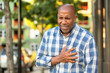 © digitalskillet1 - African American man having pains holding his chest.