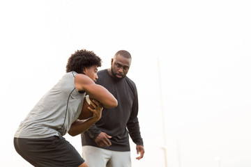 Wall Mural - American Football coach training a young athlete.