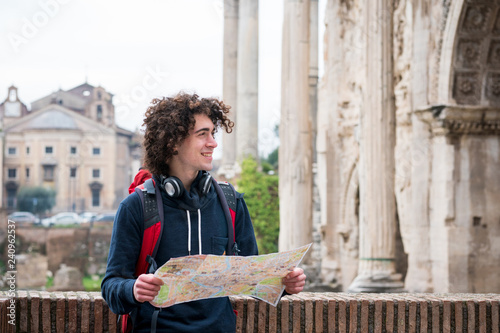 Foto Handsome tourist holding a tourist map near Roman forum in Rome, Italy