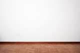 Fototapeta Tęcza - Empty room with brown wooden tiled floor and white blank wall