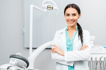 Wall Mural - beautiful dentist standing with crossed arms in dental clinic