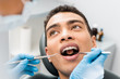 © LIGHTFIELD STUDIOS - african american man with open mouth during checkup in dental clinic