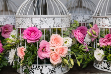 Various Bridal Flower Heads In Vintage Ornate Bird Cage As Bloom Decoration At A Wedding Reception