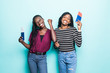 © F8  \ Suport Ukraine - Two young african vacation girl rejoicing their holiday with passports and travel tickets in hands isolated over blue background