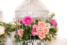 Various Bridal Flower Heads In Vintage Ornate Bird Cage As Bloom Decoration At A Wedding Reception