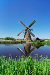 Canvas Print - dutch windmill over river waters