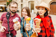 Happy group of friends eating ice-cream in old town center in Italy, travel and food concept