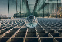 Close Up Of A Glass Sphere. Metal Floor And Glass Tunnel.