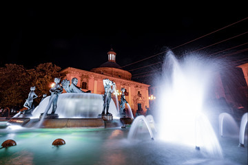 Valencia Turia river fountain in Plaza de la Virgen square of Spain. Night and slow shutterspeed shot with wide angle lense.