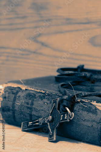 Fotografie, Obraz Crucifix necklace on a bible with wood background with colour toning