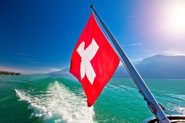 Wall Mural - Flowing on idyllic Swiss lake Lucerne boat flag view