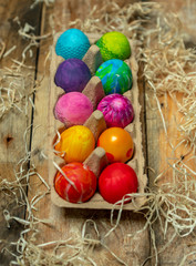 beautiful, bright, very colorful hand-painted eggs on a contrasting, raw, natural background from wooden planks