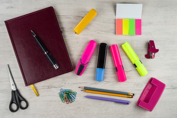 a notebook and various stationery on the light table surface.