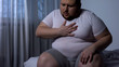 © motortion - Overweight man feeling chest pain, health body care, heart attack, dyspnea
