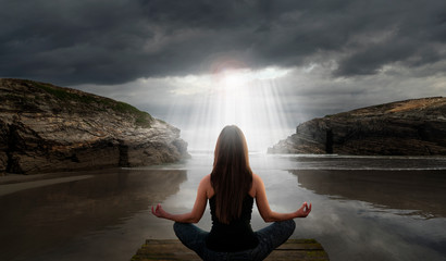 Wall Mural - Woman in yoga pose in front of the sea