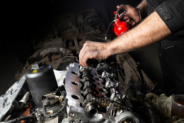 Mechanic hand checking and fixing a broken car in car service garage