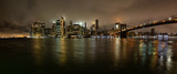 Fototapeta  - Panoramic view of the Downtown Manhattan and Brooklyn Bridge during a foggy night. Taken in New York, NY, United States.